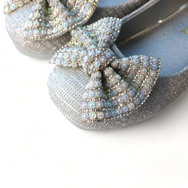 Close up of girls silver sparkle Mary Jane shoes showing rhinestone bow
