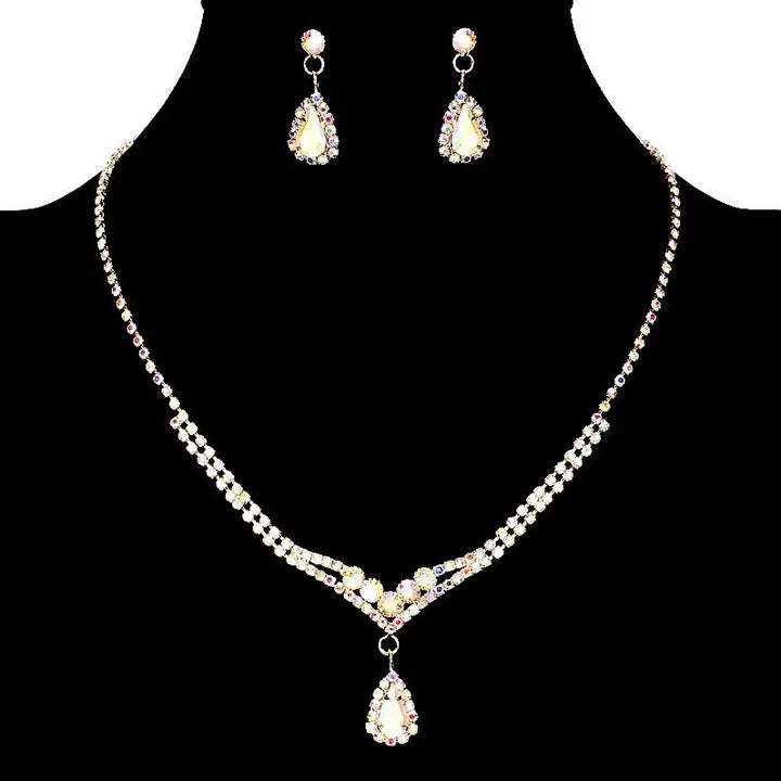 Gold Abstract Crystal teardrop necklace and earring set with rhinestone V-shaped chain and matching drop earrings on black background