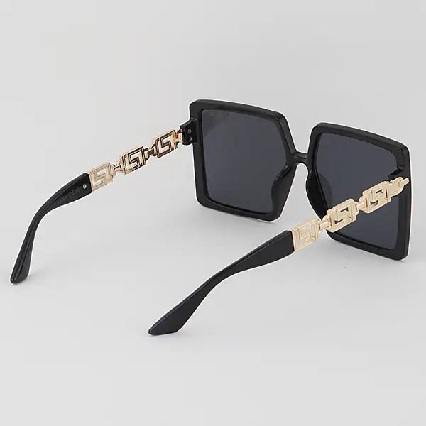 Black square sunglasses with gold Greek key trim on temples