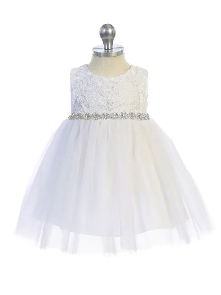 Baby girl wearing white lace tulle dress with braided rhinestone waist detail - front view