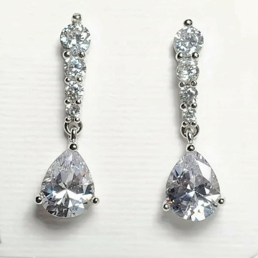 Pair of silver teardrop earrings with clear gemstones on a white background