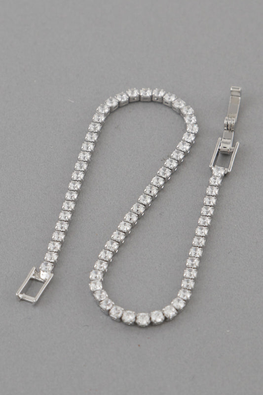 Silver bracelet with clear stones on a gray background