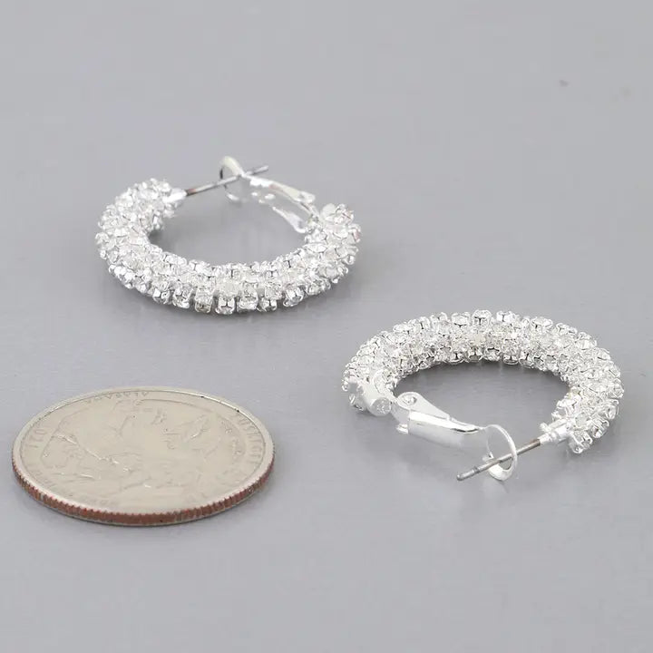 Silver rhinestone-wrapped petite hoop earrings displayed with quarter coin for size reference, showing full sparkle detail and snap closure