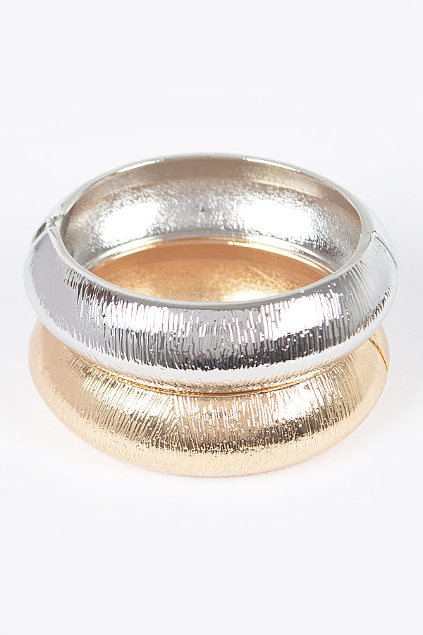 Stacked gold and silver textured hinged bangle bracelets showing brushed metal detail