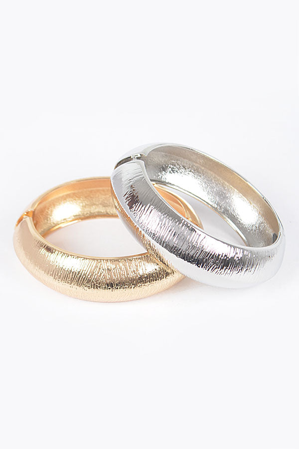 Two-piece brushed metal bracelet set in gold and silver with textured finish