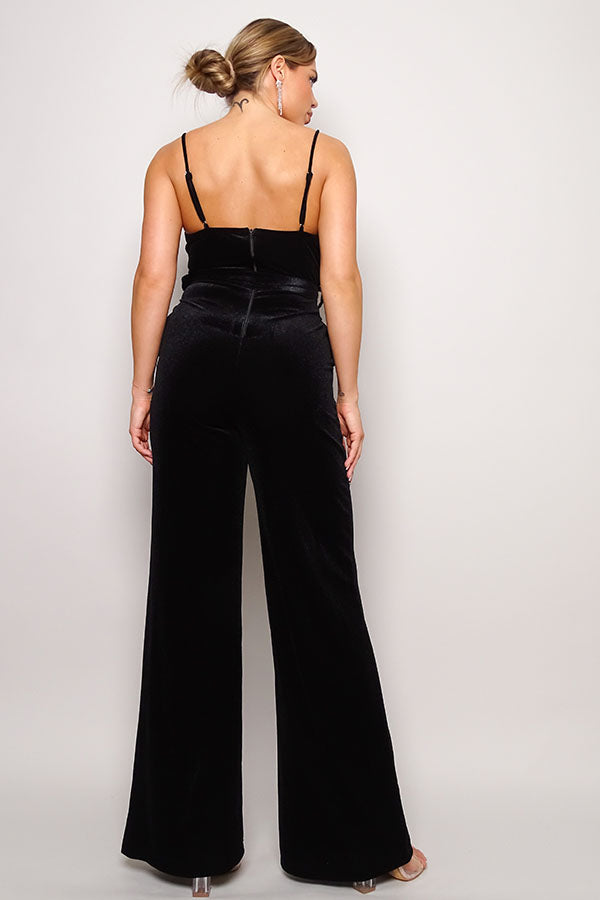 Woman in black velvet palazzo jumpsuit with rhinestone embellished belt and wide-leg silhouette