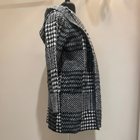 Black and white houndstooth hooded coat in eyelash mink fabric, left side profile showing relaxed fit and geometric pattern detail on dress form