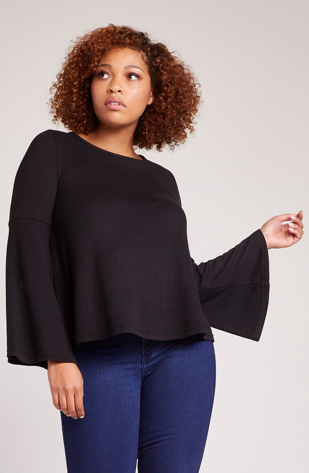 Black bell sleeve top on model - front view showing relaxed fit and dramatic flared sleeves