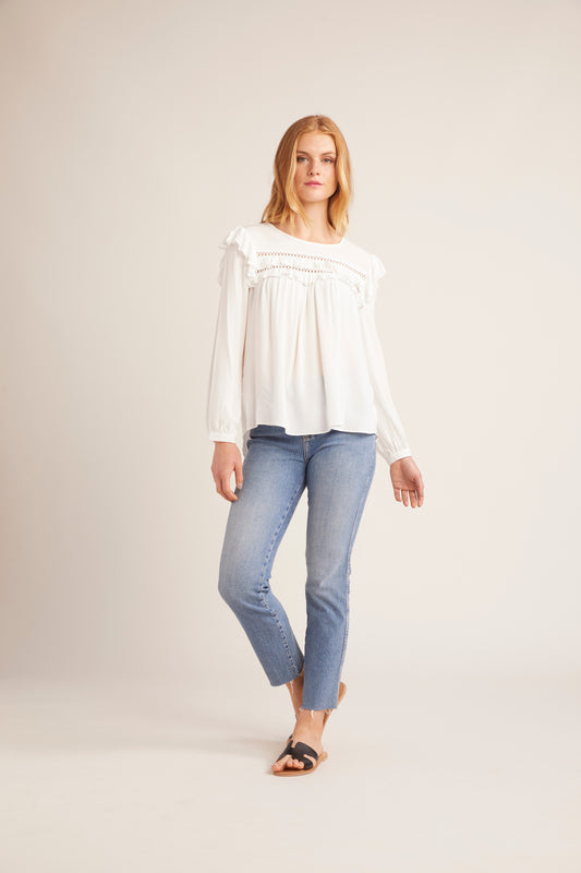 Woman wearing a dark blue blouse and blue jeans on a plain background