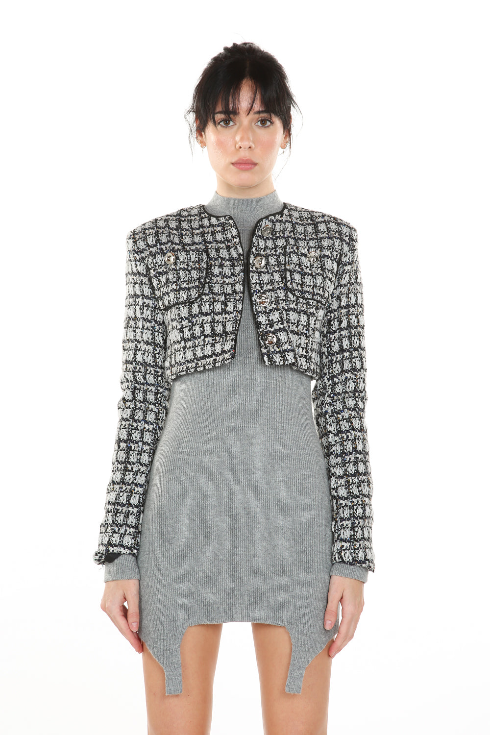 Woman wearing a gray dress with a black and white patterned jacket on a white background