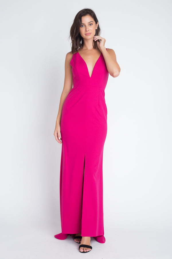 Woman wearing hot pink gown with deep V-neckline and spaghetti straps, full-length front view showing floor-length silhouette
