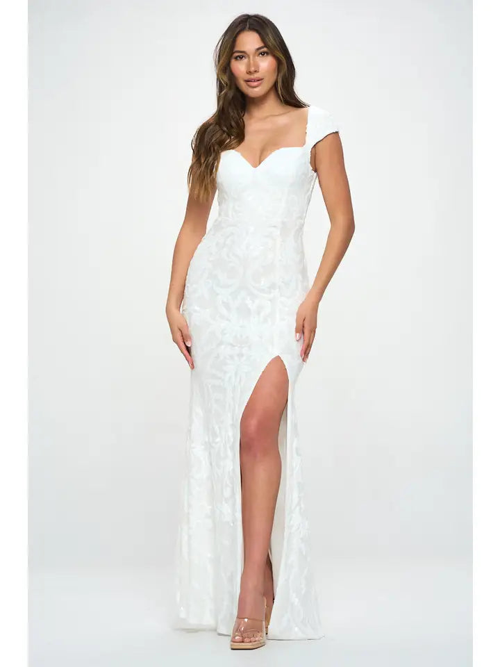 Woman wearing a white shimmering sequin maxi gown with cap sleeves and high slit