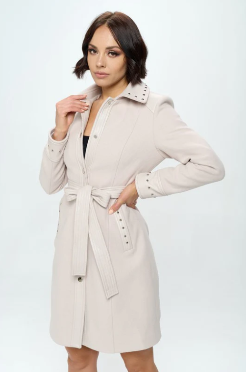 Side view of blush pink faux wool dress coat showing structured tailoring and removable waist belt with stud accents
