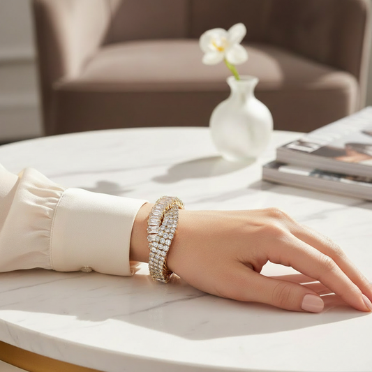 CZ pavé statement bracelet with sparkling cubic zirconia stones worn on a wrist, delicate gold finish bracelet resting on marble surface, women's luxury statement jewelry