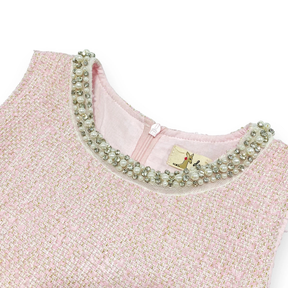 Close-up of pearl and rhinestone embellished collar with gold accent on pink tweed dress