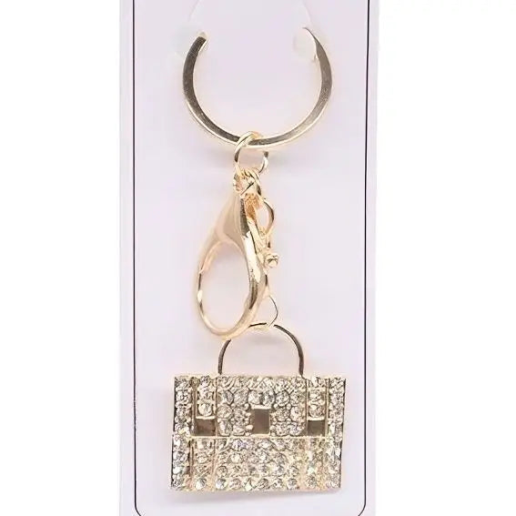 Gold rhinestone handbag keychain charm with chain link attachment on gold keyring against white background