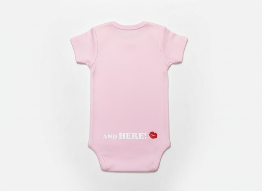 Back view of pink Grandma Was Here onesie showing and here text on white background