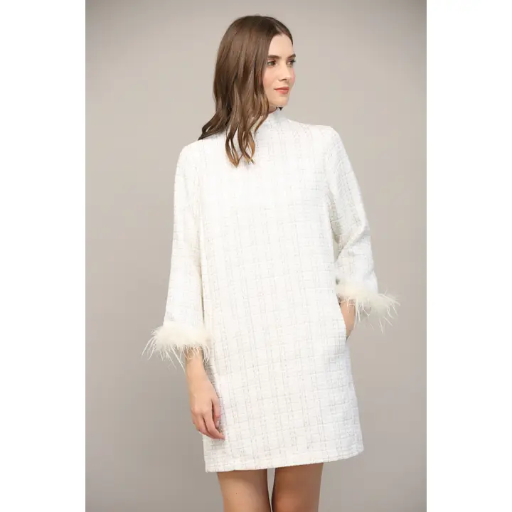 Side angle of white feather-sleeve mini dress showing lurex textured fabric detail and shift silhouette