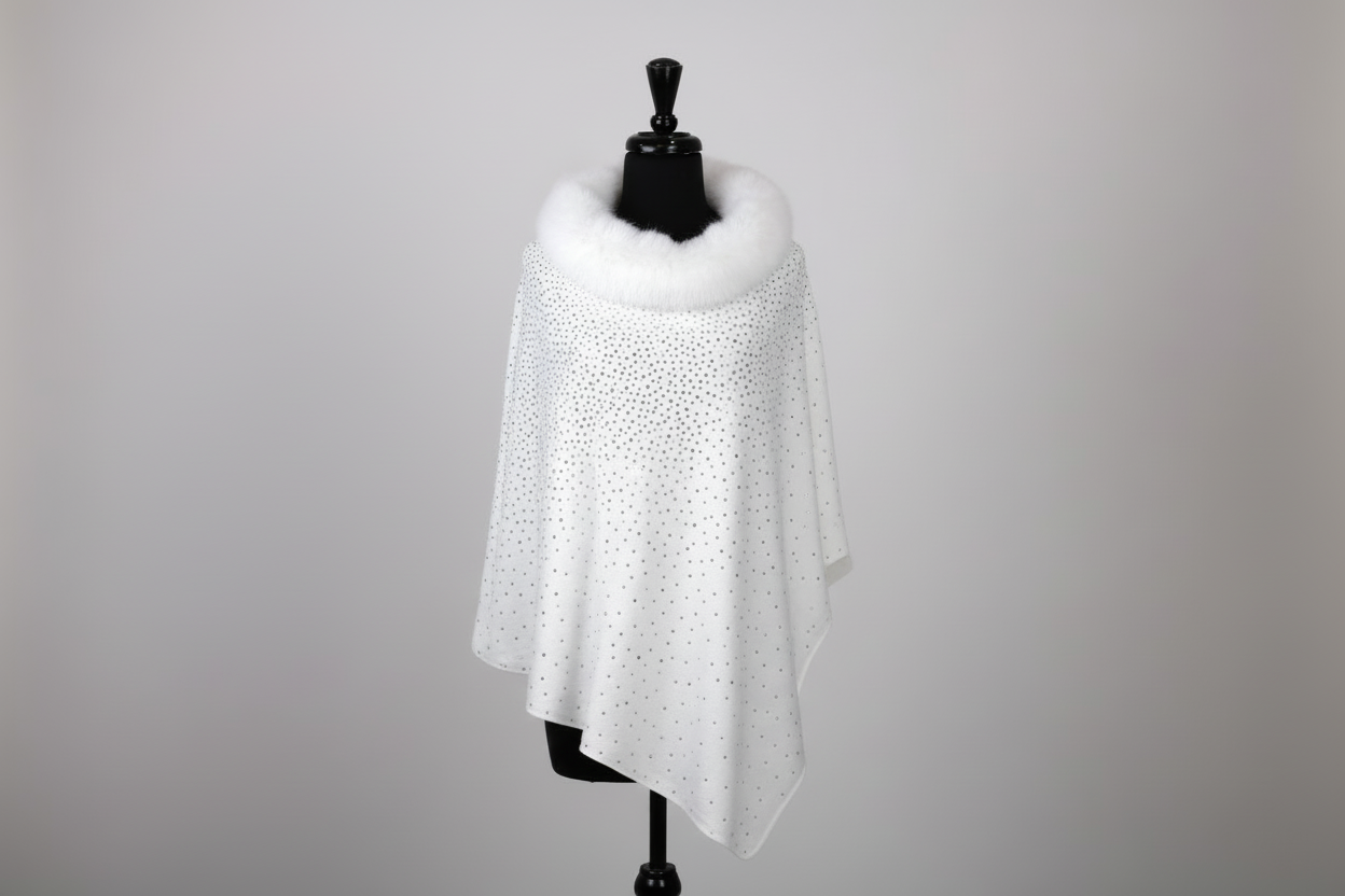 White sparkle poncho with rhinestone embellishments and white faux fur collar detail - luxury winter wrap product photography