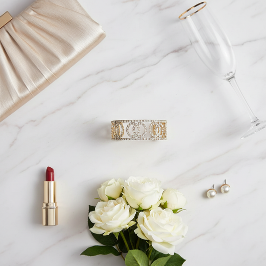 Rhinestone interlocking circle cuff bracelet styled on marble with champagne flute, white roses, evening clutch, and pearl earrings for glamorous occasion aesthetic