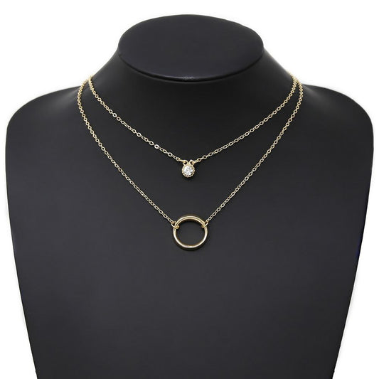 A gold-colored metal hoop and glass stone charm layered short necklace displayed on a black mannequin.