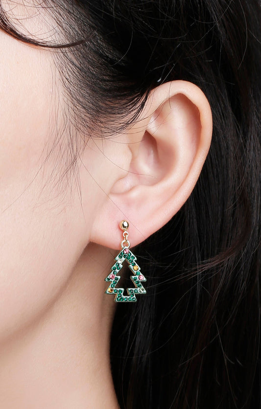 Close-up of girl wearing festive Christmas tree earrings with green crystals and colorful stones, gold-tone ball stud