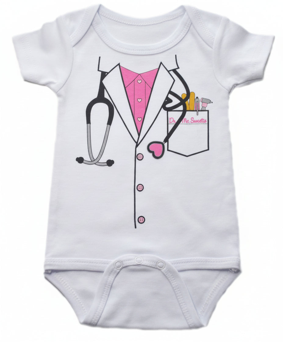 White baby onesie with doctor lab coat graphic featuring pink shirt with heart buttons, stethoscope, and pocket with Dr. McSweetie name tag and medical tools