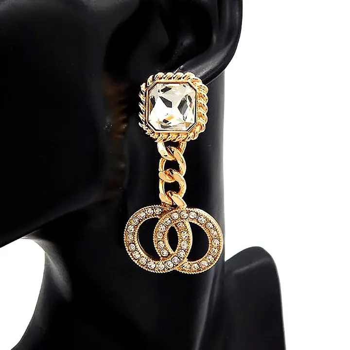 Luxury gold drop earrings featuring square crystal stud top with rope-textured frame, chunky chain link connector, and double interlocking rhinestone-encrusted circles, displayed on black mannequin ear