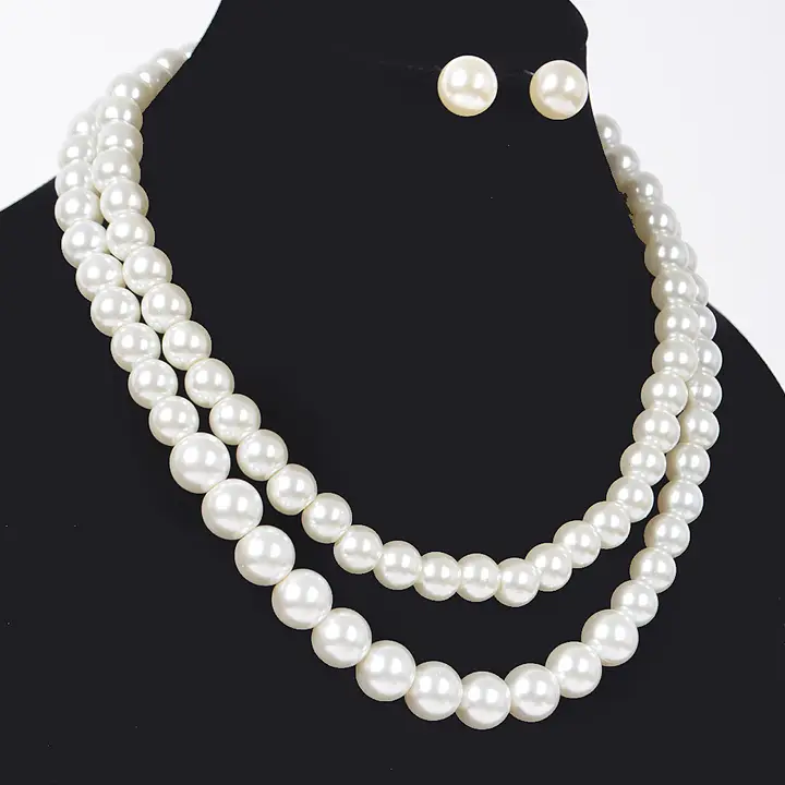 Double strand white pearl necklace set with gold-tone hardware and pearl earrings displayed on black bust