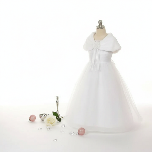 White faux fur shawl draped on white dress with minimalist pink and silver holiday decor