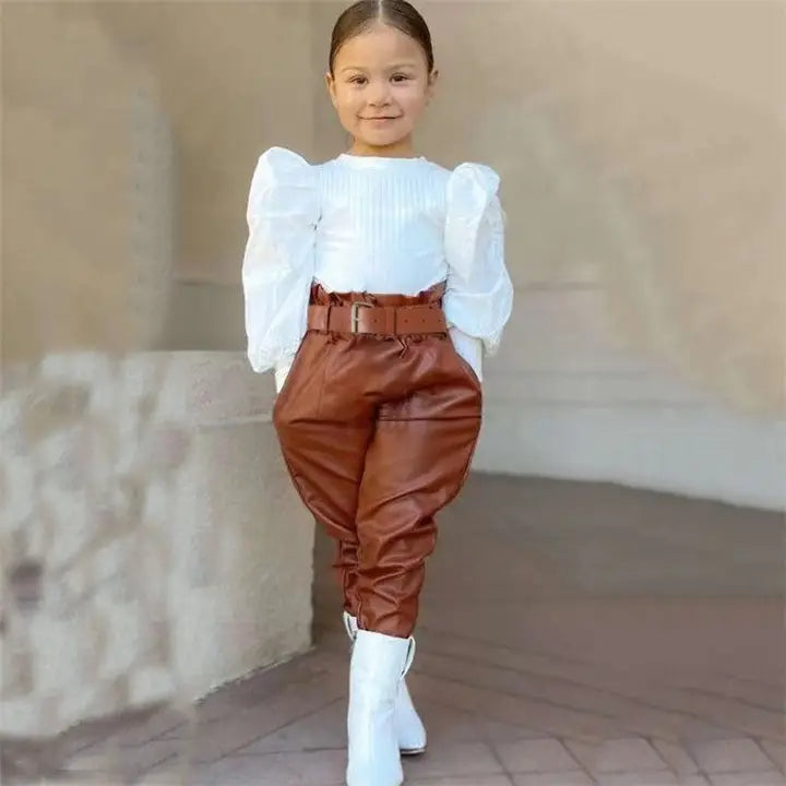 Girl wearing white puff sleeve top with brown high-waisted belted pants and white boots