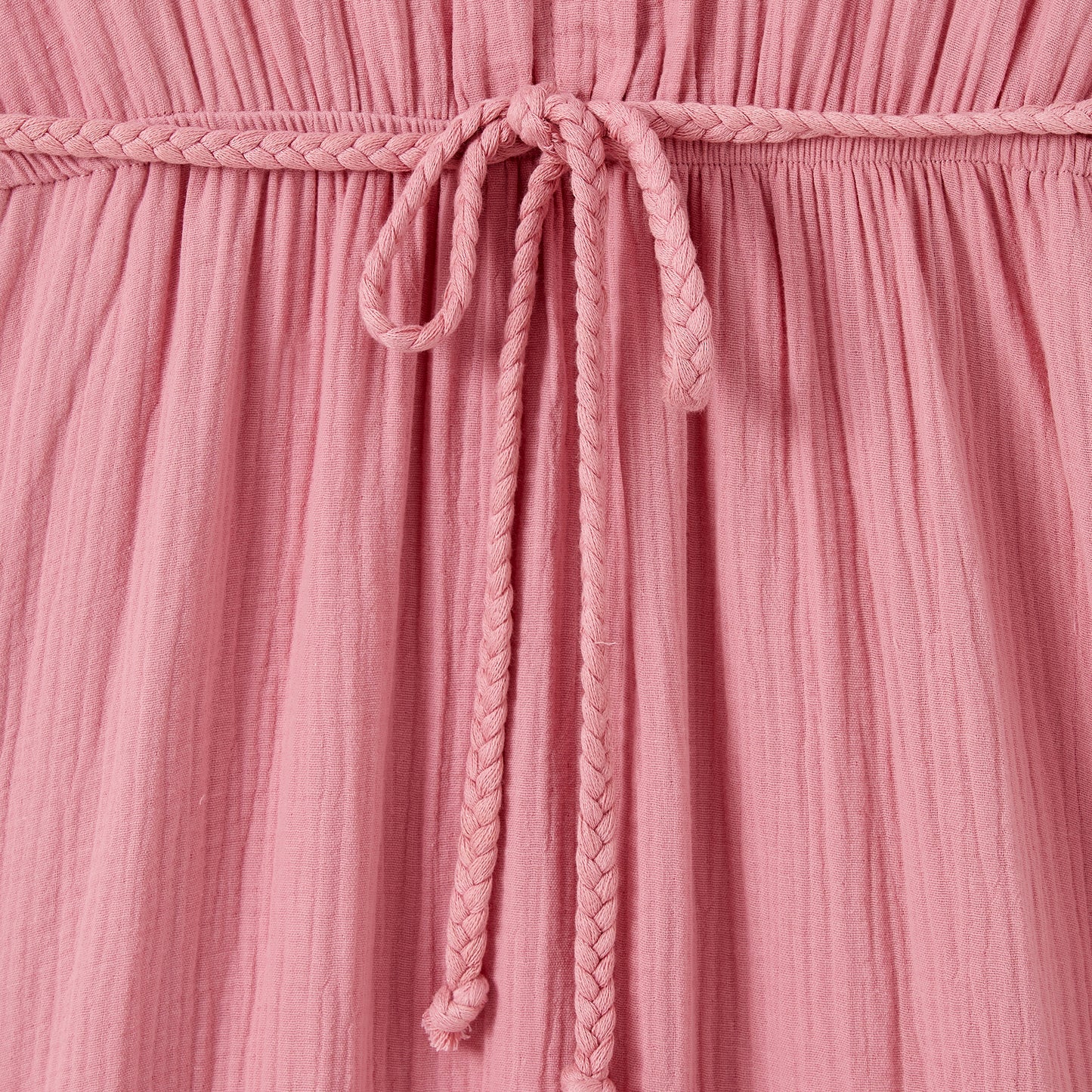 Close-up of a pink textured fabric with a braided drawstring.
