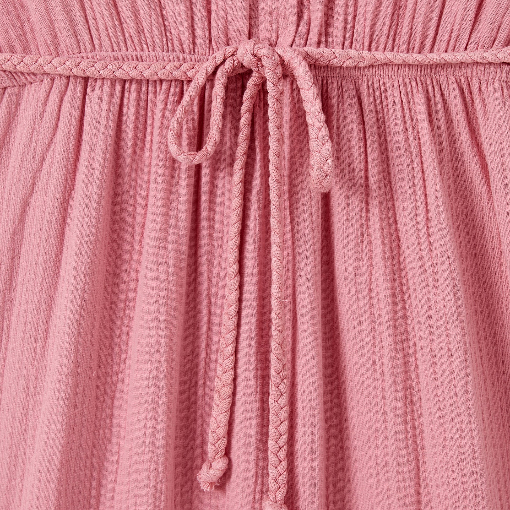 Close-up of a pink textured fabric with a braided drawstring.