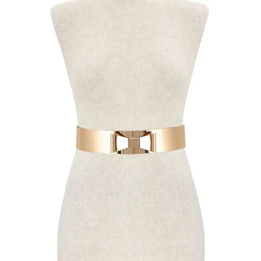 Metal ribbon bow belt styled on dress form showing waist-cinching fit and polished gold bow detail
