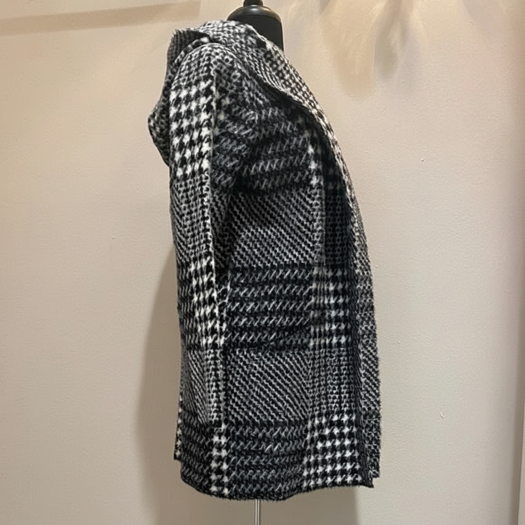 Black and white houndstooth hooded coat in eyelash mink fabric, left side profile showing relaxed fit and geometric pattern detail on dress form