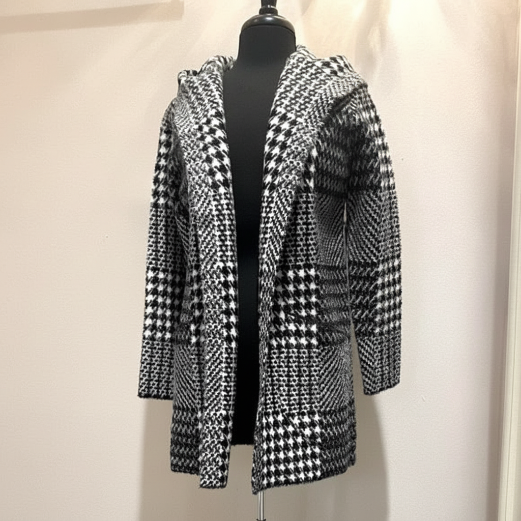 Black and white houndstooth hooded coat with mixed geometric patterns, open front styling, and relaxed fit shown on dress form, front view