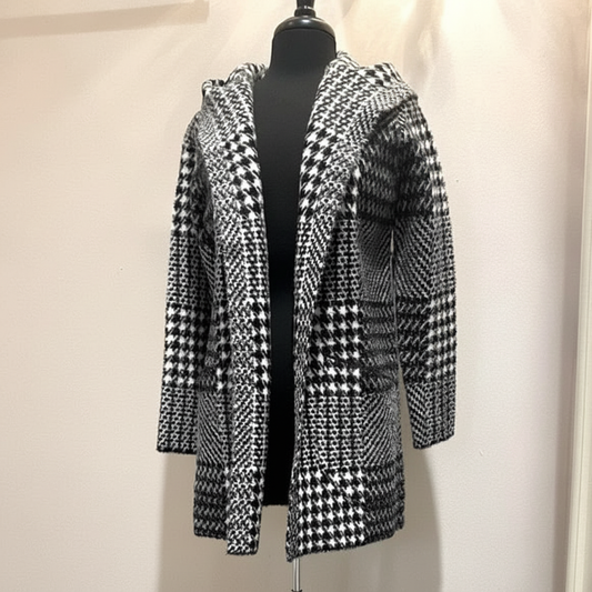 Black and white houndstooth hooded coat with mixed geometric patterns, open front styling, and relaxed fit shown on dress form, front view