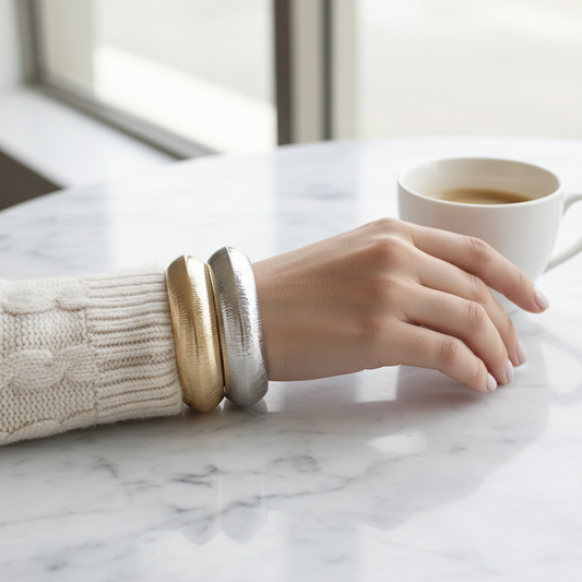 Woman wearing gold and silver textured bangle bracelets on wrist, lifestyle styling