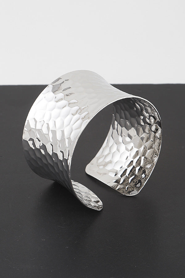 ide hammered silver cuff bracelet with textured finish on black background showing dimensional detail