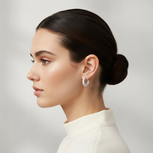 Woman wearing silver rhinestone-wrapped petite hoop earrings with sleek updo hairstyle, side profile showing earring sparkle