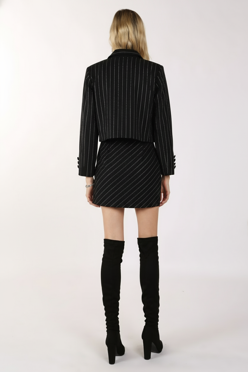 Back view of black rhinestone embellished blazer and skirt set showing diagonal pinstripe detailing across shoulders and skirt