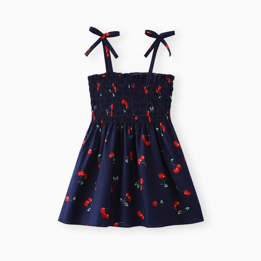 Infant navy blue dress with red cherry print and bow accents on the straps.