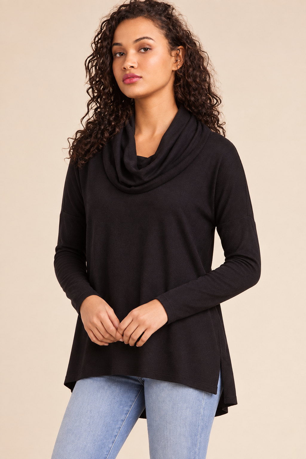 Women's black cowl neck long sleeve sweater with high-low hem, styled with light blue jeans for fall and winter.