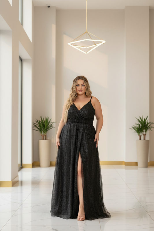 Plus size woman in black glitter mesh A-line gown — deep V neckline, spaghetti straps, high front slit, minimalist white and gold lobby setting