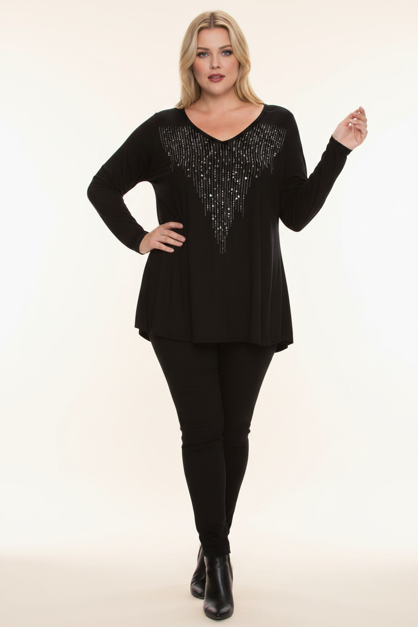 Plus size woman in black rhinestone fringe V-neck tunic styled with black skinny jeans and heeled ankle boots — full length front view,