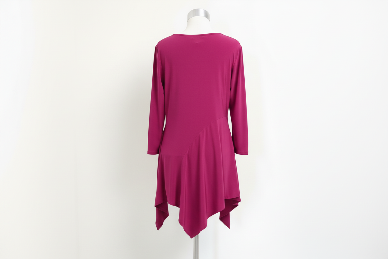 Back view of vibrant magenta asymmetric tunic on elevated dress form with white marble floor, bright studio lighting, luxury boutique presentation