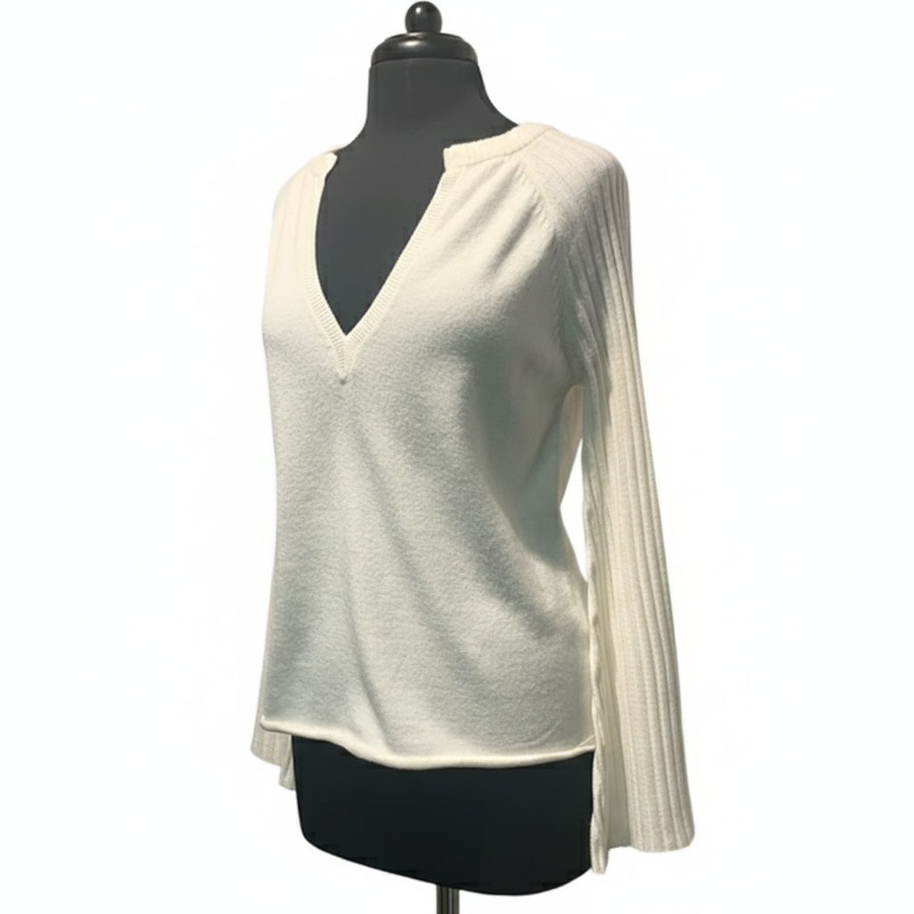 Side view of cream ribbed sweater showing bell sleeve and relaxed fit