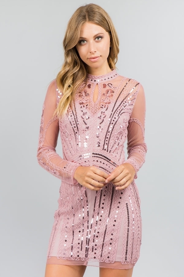 This image features a stylish pink long-sleeved beaded dress, perfect for adding a touch of elegance to special occasions. The dress is adorned with intricate beaded patterns that add texture and interest, while the high neckline and sleeve design provide a contemporary look.