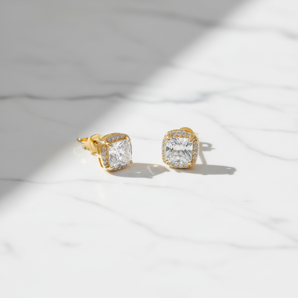 Flat lay of gold-tone petite CZ stud earrings on marble