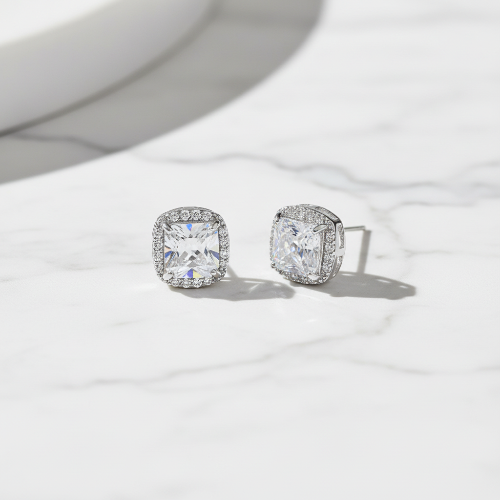 Flat lay of silver-tone petite CZ stud earrings on marble